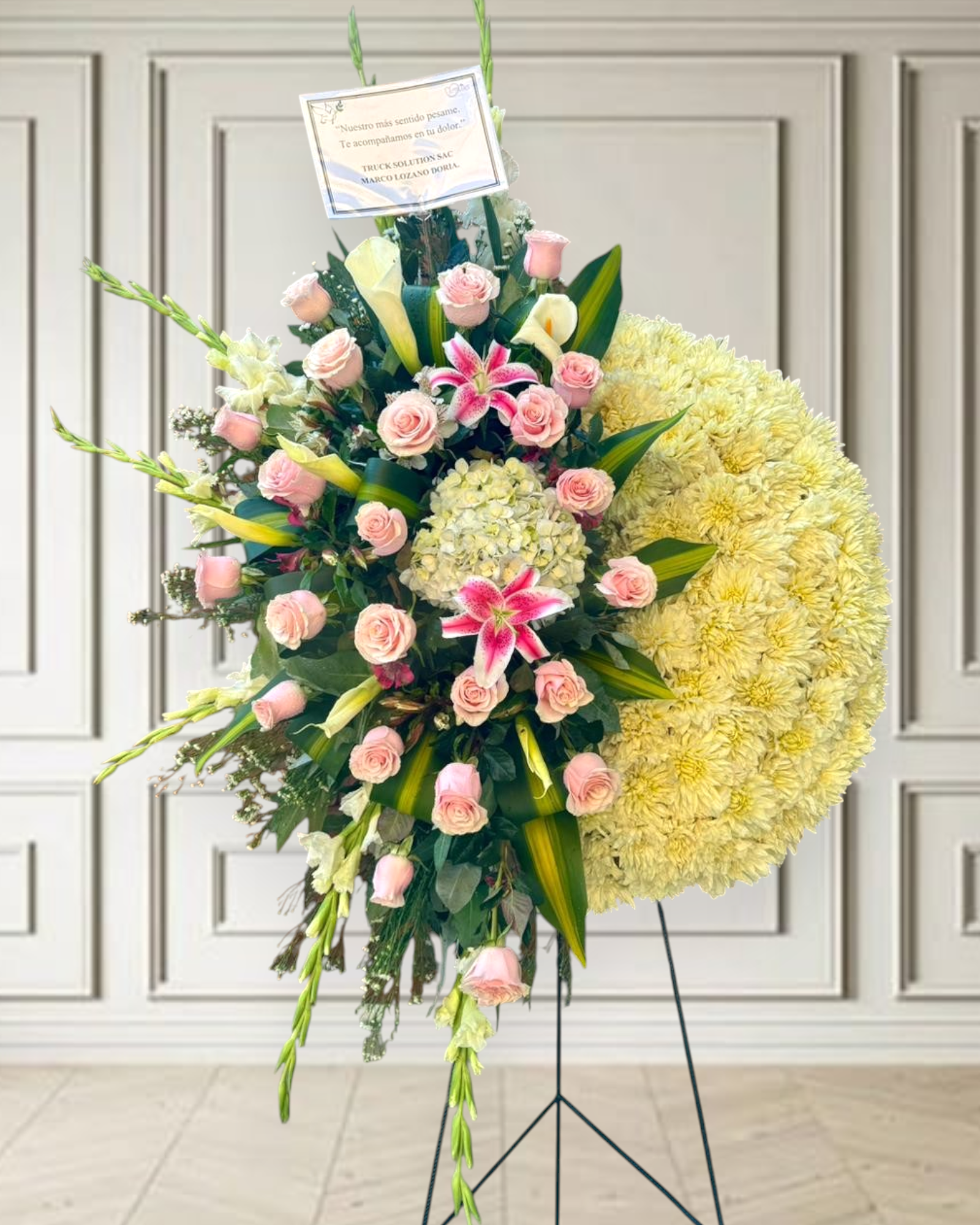Corona floral fúnebre media luna con rosas rosadas bebé